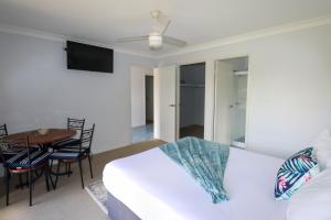 a bedroom with a bed and a table and chairs at BLK Stays Guest House Deluxe Units Morayfield in Morayfield