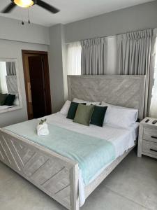 a bedroom with a large bed with green and white pillows at New: Centric, City View, SofaBd in Santo Domingo