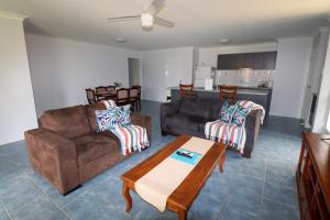 a living room with two couches and a table at BLK Stays Guest House Deluxe Units Morayfield in Morayfield