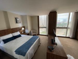 a hotel room with a bed and a large window at PROMOÇÃO EXECUTIVA COM BANHEIRA E FLATS SEM BANHEIRA- Melhor Hotel De Taguatinga in Taguatinga