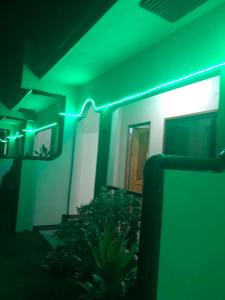 een groen licht aan de zijkant van een gebouw bij AMK traveller's hub in Maite