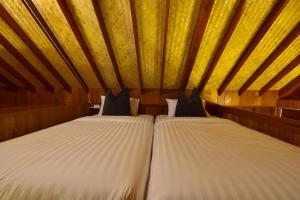 a couple of beds in a room with a ceiling at 500 Rai Floating Resort in Ratchaprapha