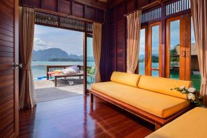 a living room with a couch and a view of the water at 500 Rai Floating Resort in Ban Chieo Ko