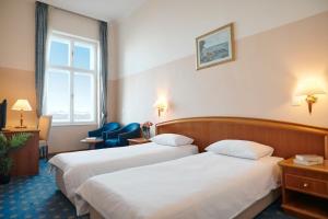 Habitación de hotel con 2 camas y ventana en Hotel Lovran, en Lovran