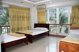 a bedroom with two beds and a large window at Catba Beach House in Cat Ba
