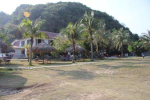 a resort with palm trees and a building at Catba Beach House in Cat Ba