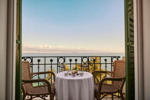 a table with a white table cloth on a balcony at Hotel Lovran in Lovran