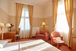 a hotel room with a bed and a chair at Hotel Lovran in Lovran