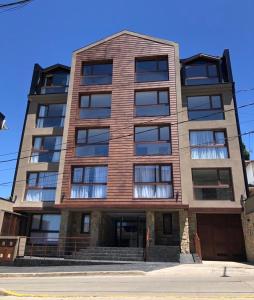 un edificio alto de ladrillo con ventanas en una calle en Departamento a metros del Centro Cívico en San Carlos de Bariloche