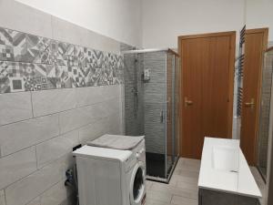 ein Bad mit einer Waschmaschine und einer Dusche in der Unterkunft Casa Trezza in Latina