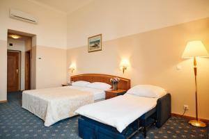 a hotel room with two beds and a lamp at Hotel Lovran in Lovran +37 photos