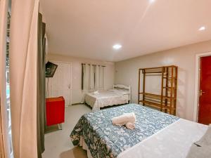 a bedroom with two beds and a red cabinet at Garden 437 Estúdios in Florianópolis