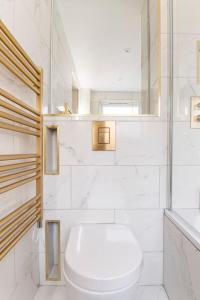 een witte badkamer met een toilet en een wastafel bij Riverside serviced apartments in Londen