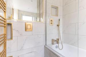 een witte badkamer met douche en wastafel bij Riverside serviced apartments in Londen +29 foto's