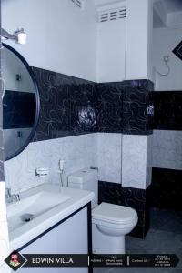 bagno con servizi igienici, lavandino e specchio di Edwin Villa a Trincomalee
