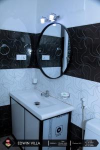 a bathroom with a sink and a mirror at Edwin Villa in Trincomalee