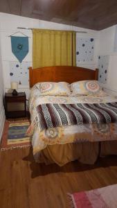 a bedroom with a bed with a blanket and a window at Agradable Cabaña campestre a 7 minutos de Osorno in Osorno