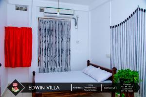 a small room with a bed and a curtain at Edwin Villa in Trincomalee