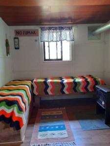 Habitación con 2 camas y ventana en Agradable Cabaña campestre a 7 minutos de Osorno en Osorno