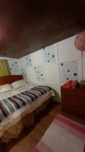 a bedroom with a bed and a wall with tiles at Agradable Cabaña campestre a 7 minutos de Osorno in Osorno