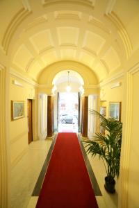 un grand couloir avec un tapis rouge et une passerelle rouge dans l'établissement Hotel Giugiù, à Rome