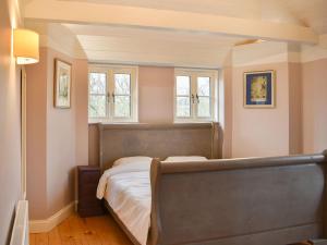 a bedroom with a bed and two windows at Petham Hide in Petham