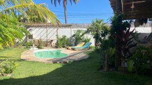 Casa Pura Vida - Icaraizinho في إيكاري: حديقة خلفية بها مسبح مع مقعد وكرسي