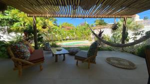 un porche con sillas, una hamaca y una piscina en Casa Pura Vida - Icaraizinho, en Icaraí