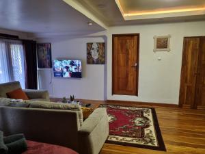 uma sala de estar com um sofá e uma porta de madeira em Suci's Friendly Appartment em Mataram