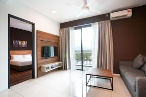 Sunway Onsen Hospitality Suites في ايبوه: غرفة معيشة فيها سرير واريكة وتلفزيون