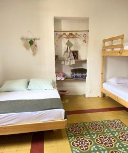 a bedroom with two beds and a rug at La Casona Espacio Bonito in Zapatoca