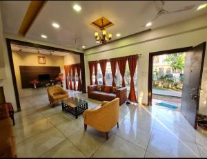 a living room with a couch and a table at Modern Villa One in Lonavala