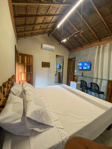 a large white bed in a room with chairs at Suítes Naldiane in Imbassai +117 photos