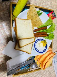 une assiette blanche avec des sandwichs et des légumes sur une table dans l'établissement Air Vision 98, à Katunayake