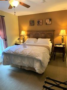 1 dormitorio con 1 cama grande, 2 mesas y 2 lámparas en The Red Coat en Niagara on the Lake