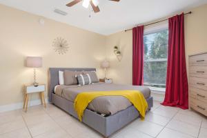 Cordova Dream Manor في سانت أوغيستين: غرفة نوم بسرير ونافذة ذات ستائر حمراء