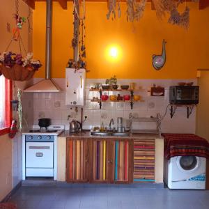 uma cozinha com um lavatório e uma máquina de lavar roupa em Casa Munay em Maimará