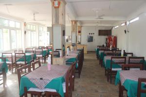 una sala da pranzo con tavoli e sedie con tovaglioli verdi di Chitwan Forest Resort , Chitwan National Park a Sauraha