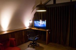a room with a desk with a television and a chair at Lucca Resort & Residence in Jepara