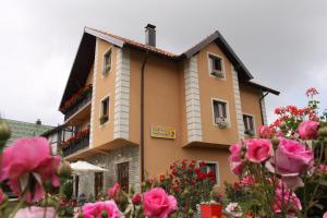 a building with pink flowers in front of it at Apartmani Ristanović in Zlatibor