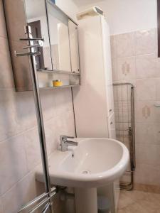 a white bathroom with a sink and a shower at Chez Papi - A 5 min da piste da Sci e Stazione CIR VDA AO 0013 in Aosta