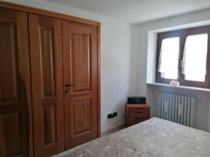 1 dormitorio con 1 cama y puerta de madera en Chez Papi - A 5 min da piste da Sci e Stazione CIR VDA AO 0013 en Aosta