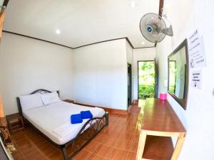 a bedroom with a bed and a fan at JR&GYM Resort in Phi Phi Don