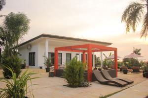 una casa con un patio con sillas frente a ella en Lucca Resort & Residence, en Jepara