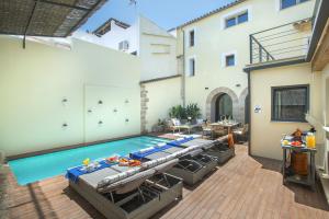 een binnenzwembad met stoelen en een tafel bij Owl Booking Villa Alvarez - Luxury Retreat in Pollença