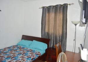 a bedroom with a bed with blue pillows and a window at Villa 34 in Cocody