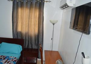 a room with a window with a bed and a lamp at Villa 34 in Cocody +27 photos
