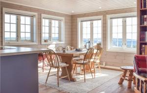 a kitchen with a table and chairs and windows at Nice Home In Sjusjen With 3 Bedrooms And Sauna in Sjusjøen
