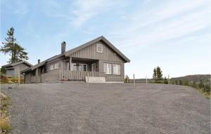 a house on a hill with a driveway at Nice Home In Sjusjen With 3 Bedrooms And Sauna in Sjusjøen