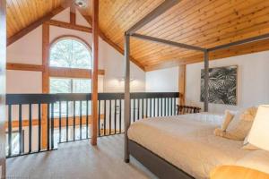 um quarto com uma cama e um tecto de madeira em Luxurious Four Season lake front cottage in Kawarthas em Kawartha Lakes